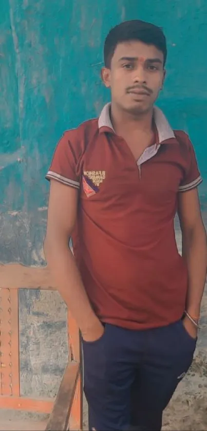 Young man in casual pose with blue background.