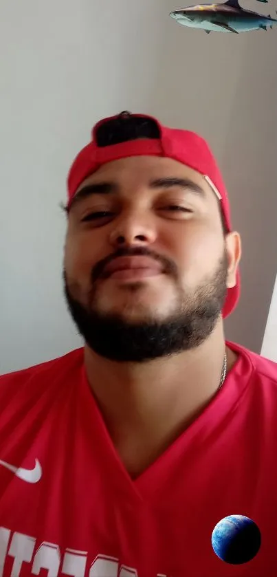 Person wearing a red shirt and cap with a soft smile.