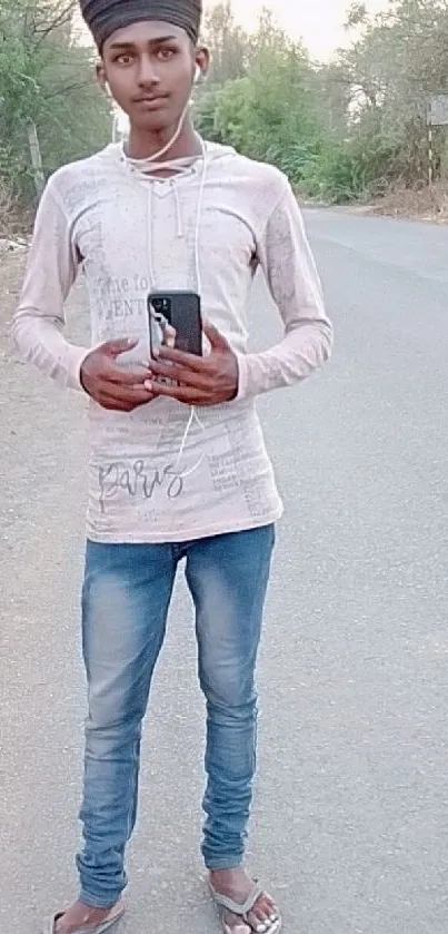 Young man posing on a tranquil country road wearing casual attire.