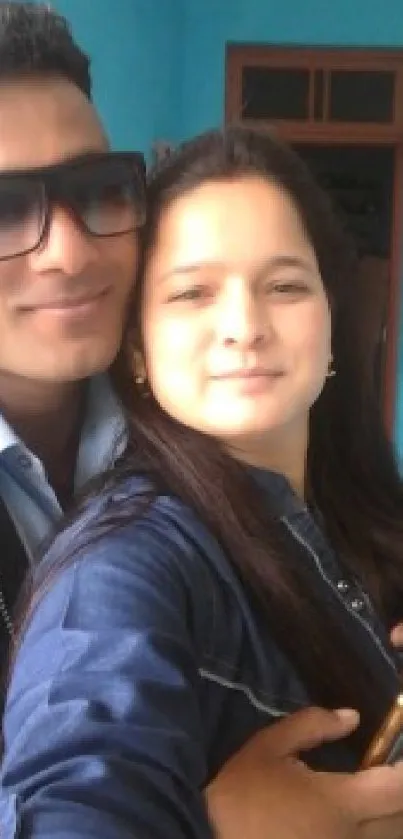 Friends posing for a cheerful selfie in casual attire with a blue backdrop.