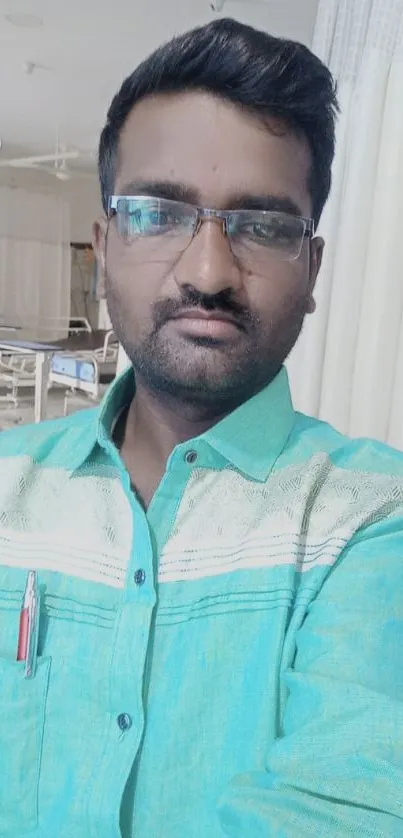 Man in light green shirt with glasses, indoor selfie.