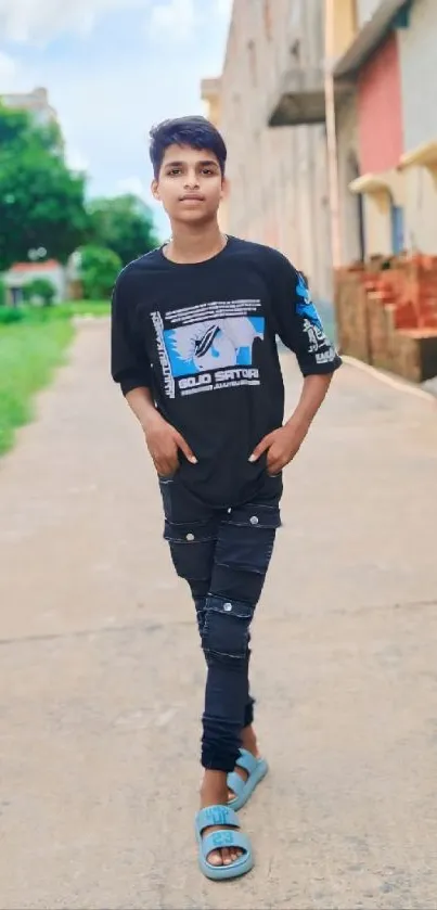 Boy in casual street style on a sidewalk with vibrant backdrop.