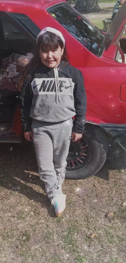 Stylish girl in sporty outfit next to a red car.