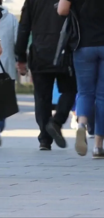 People walking on a busy street in casual attire.