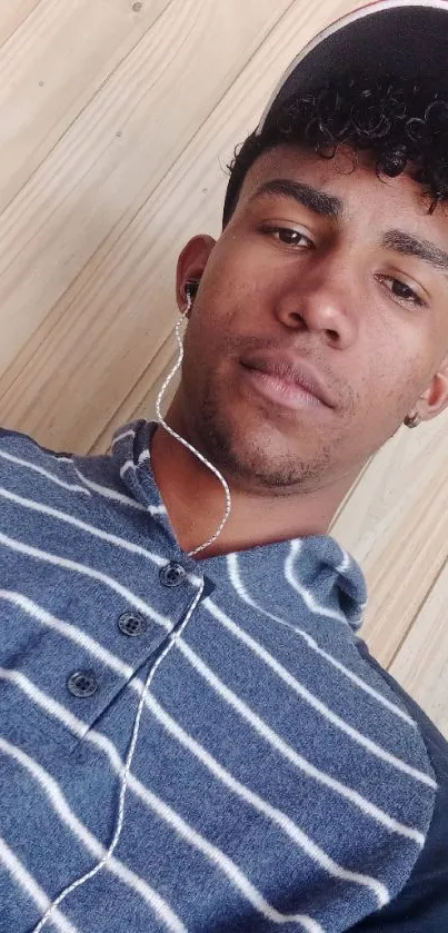 Casual portrait with striped shirt and wooden background.