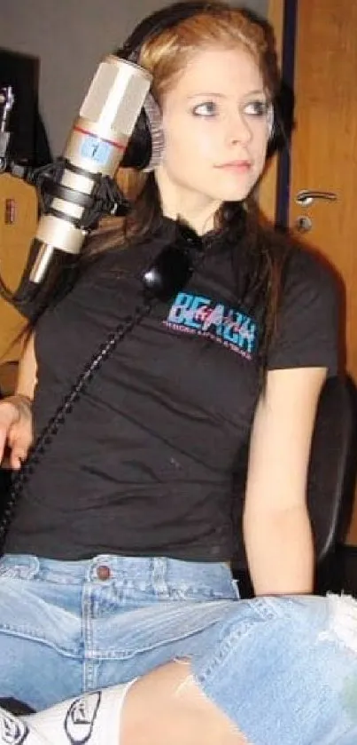 Girl in studio wearing black tee and denim.