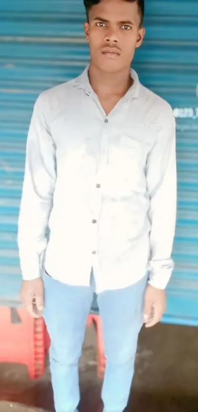 Young man in casual attire with blue shutter background.