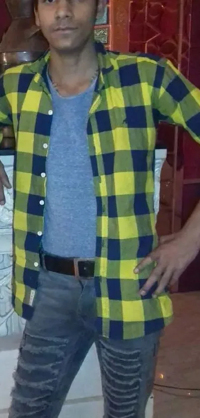 Person in yellow checkered shirt with grey tee and jeans.