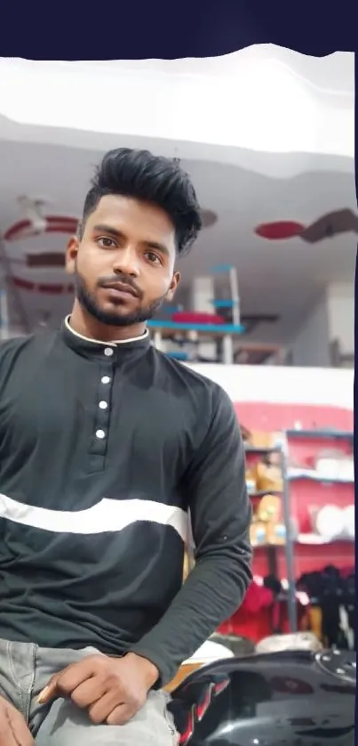 Man in a black shirt posing indoors, casual style.