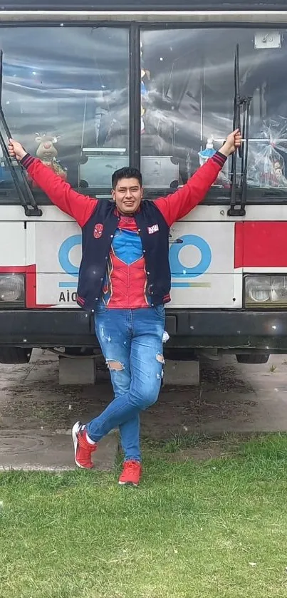 Person in vibrant outfit standing in front of a white and red bus.