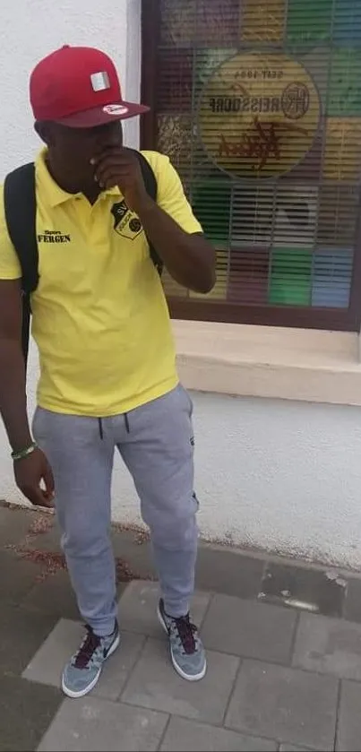 Man in casual urban attire with colorful window background.