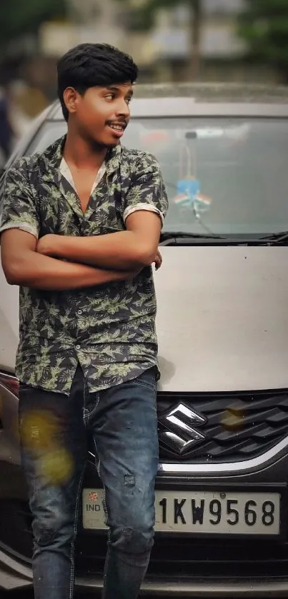 Young man leaning against a car in urban style.