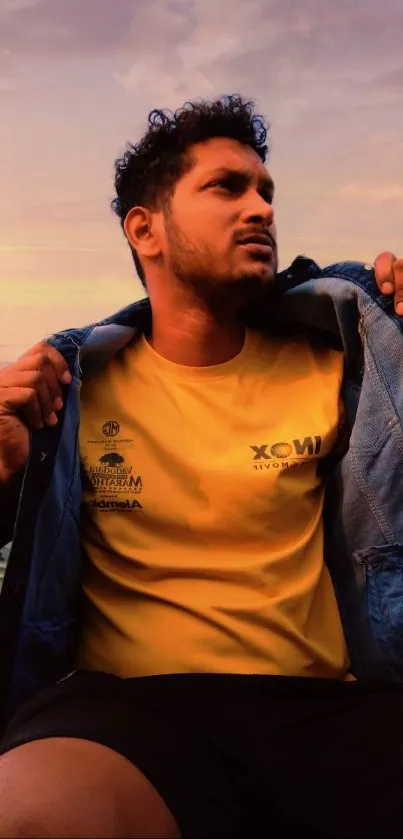 Stylish man in yellow shirt at sunset with urban background.