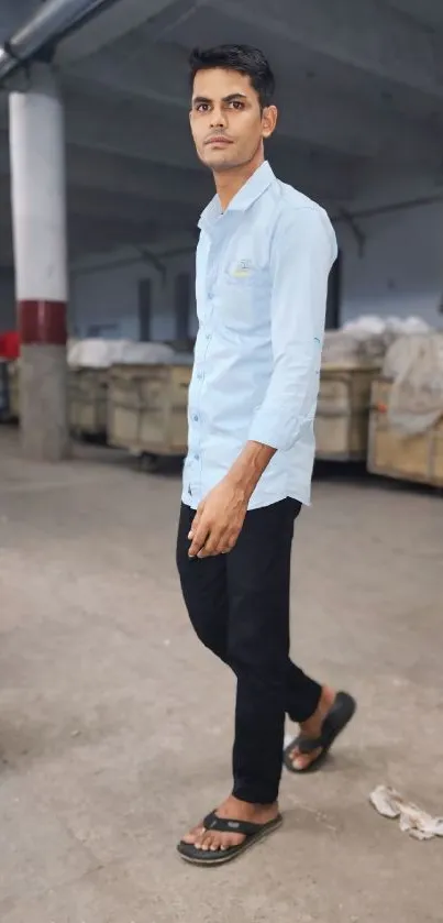 Casual style in a warehouse setting, showcasing a light blue shirt.