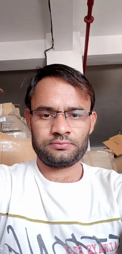 Casual portrait with warehouse boxes in background.