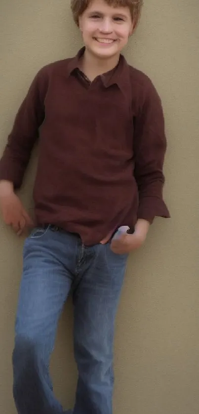 Smiling child in casual outfit against beige wall.