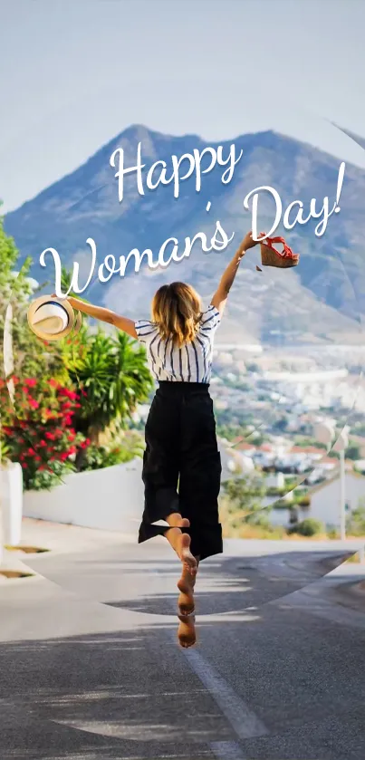 Woman joyfully jumping with Happy Woman's Day text over scenic mountain background.