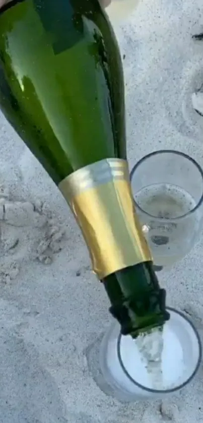 Champagne being poured into glasses on a sandy beach setting.