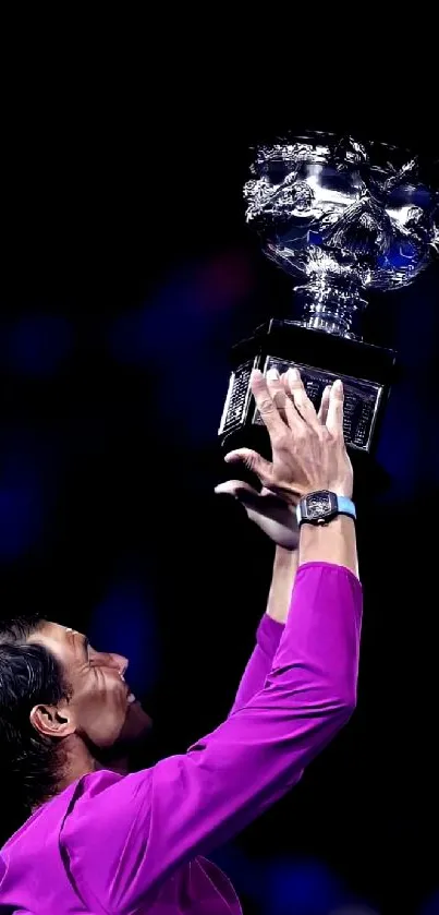 Individual raising a gleaming trophy against a dark background.