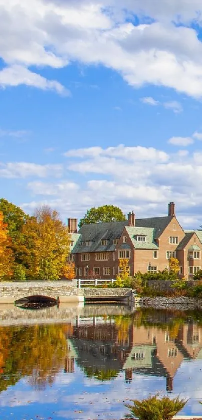 Autumn scene with mansion and lake reflection under a blue, cloudy sky.