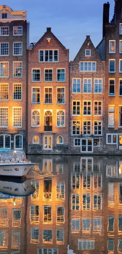 Illuminated Amsterdam canal houses reflecting on water at dusk.