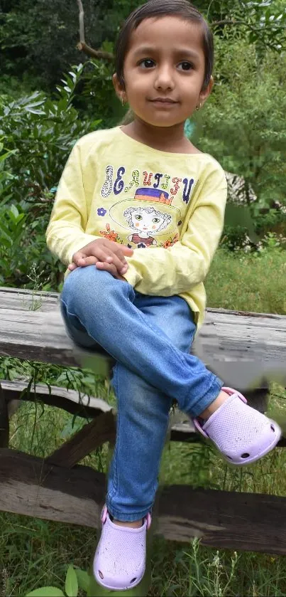 Child sitting on a bench in a lush green outdoor setting.