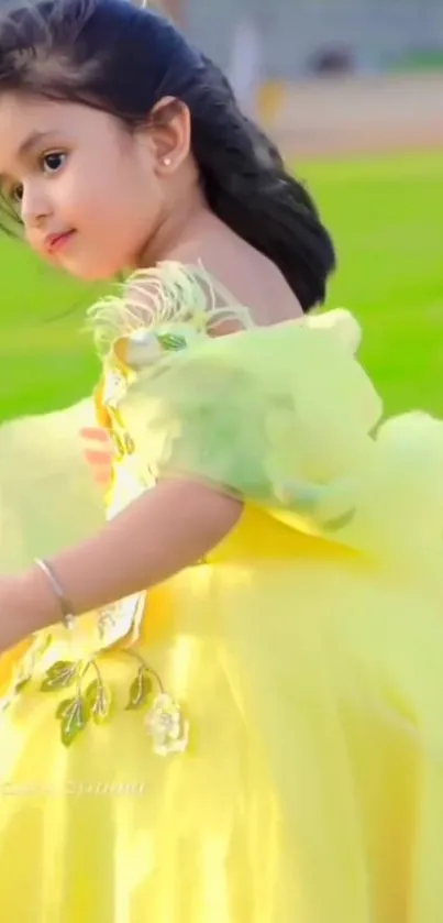 Lovely child in a bright yellow dress with a green backdrop.