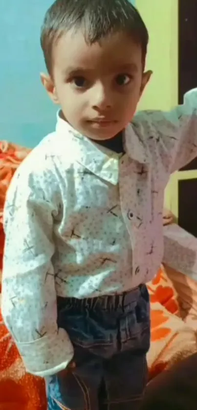 Adorable child in a stylish shirt and jeans, posing indoors.