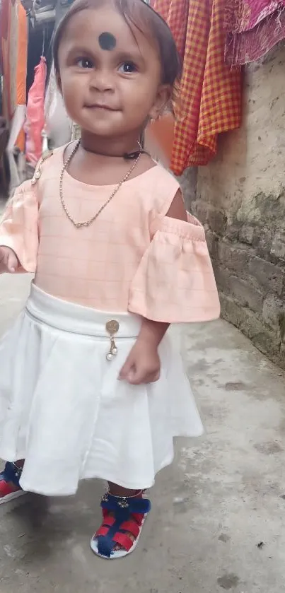 Adorable child in pastel outfit strolling on rustic street.