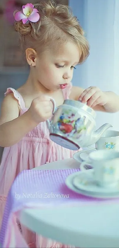 Little girl in pink dress at a tea party with floral cups.