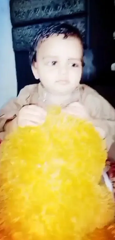 Cute child holding a fluffy, bright yellow toy.