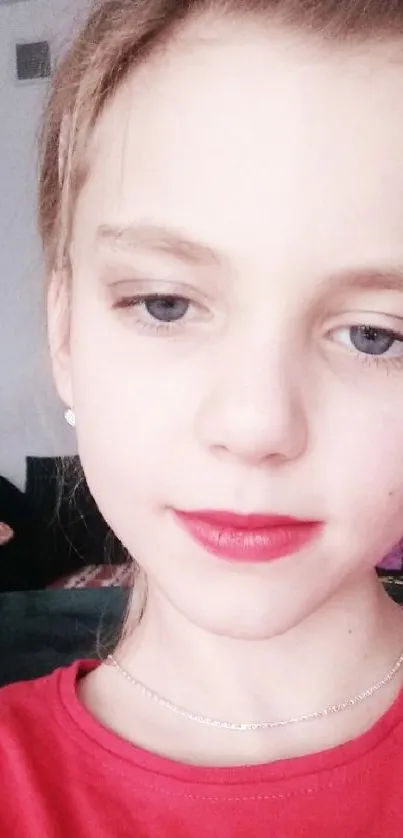 Close-up of a young girl with red lips and a boy in the background.