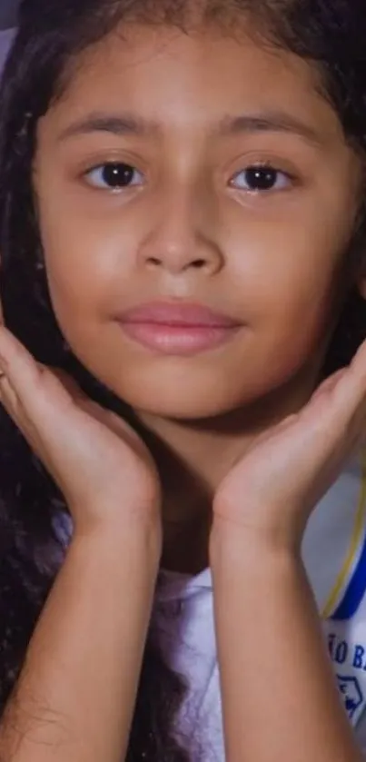 Portrait of a young girl with hands on her face.