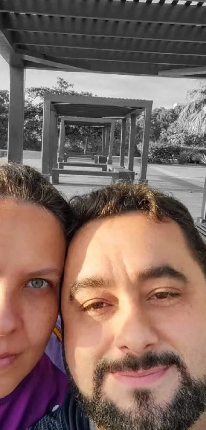 Couple surrounded by pergolas in a serene outdoor setting.