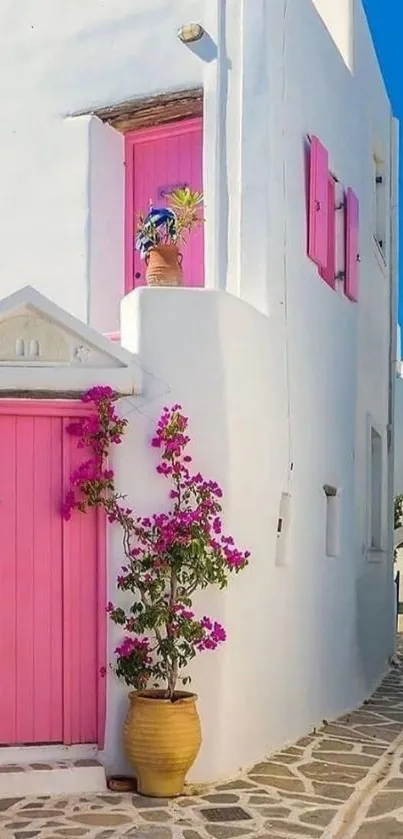 Greek island house with pink doors and blue sky.