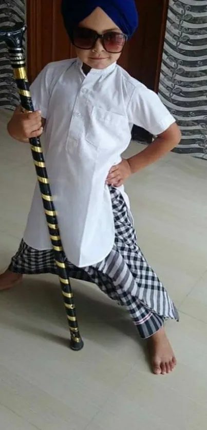 A stylish child in traditional clothing with a cane, striking a pose.