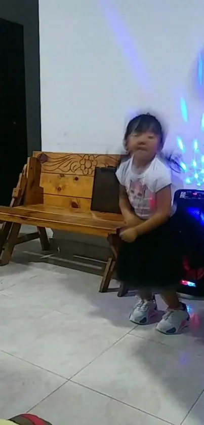 Child dancing indoors with colorful lights and wooden bench.