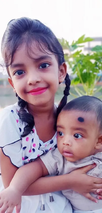 Cute smiling children sitting by a scenic lake.