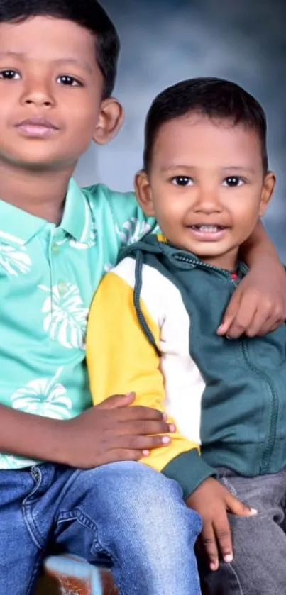 Two smiling kids posing joyfully with a teal and dark background.