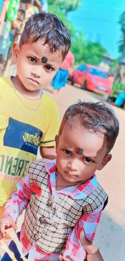 Two children posing on a vibrant street.