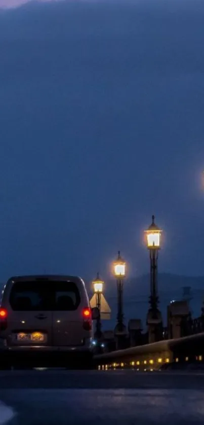 Night street with glowing lamps and car under dark blue sky.