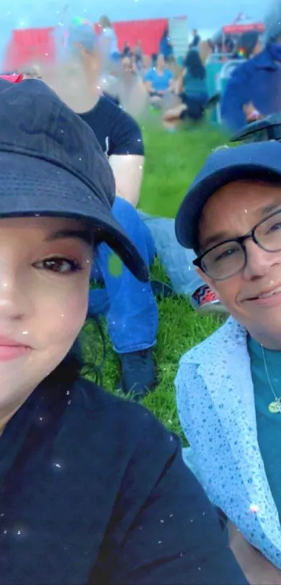 Selfie of a smiling duo outdoors, surrounded by vibrant greenery.