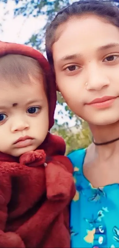 A mother holding her child outdoors with a backdrop of nature.