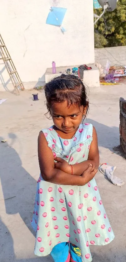 Young girl on rooftop in polka-dot dress.