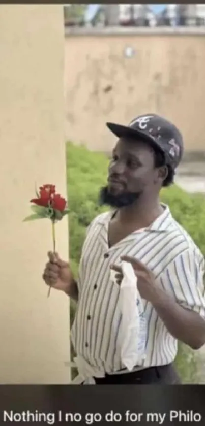 Man holds red rose in romantic wallpaper scene.