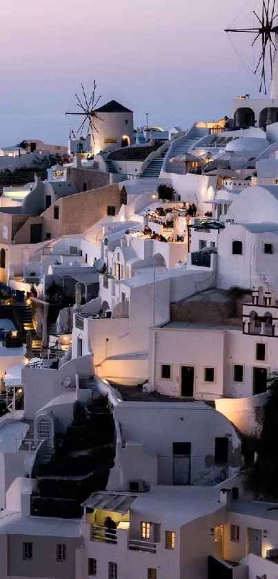 Santorini village illuminated at dusk against a lavender sky.