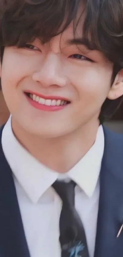 Young man smiling in a navy suit and tie.