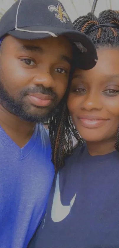 Couple smiling in casual outdoor portrait with blue and black attire.