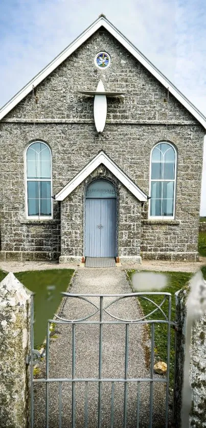 Front view of a charming stone church with Gothic architecture and a serene landscape.