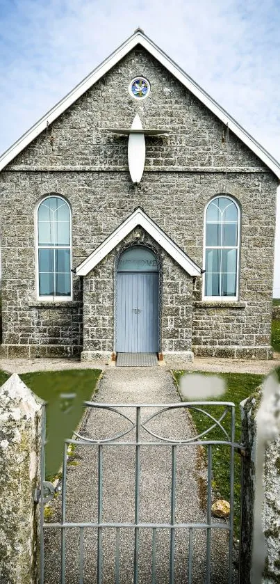 Charming stone church with blue door and gothic windows in serene countryside.